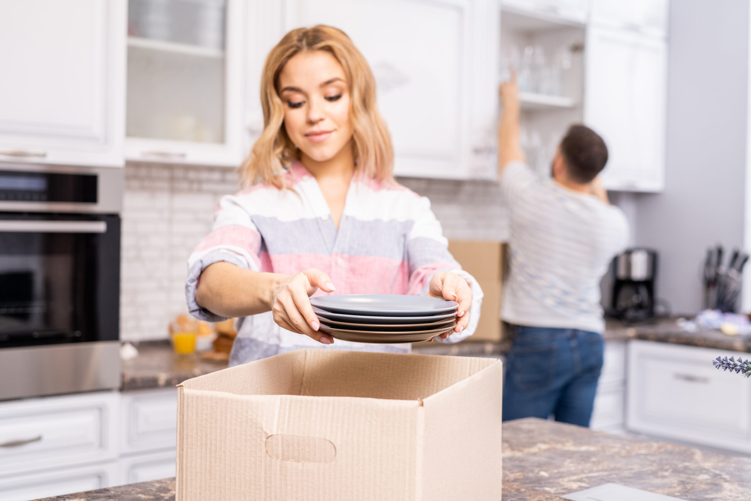 Couple Unpacking In Kitchen